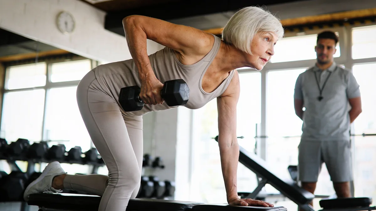 Mujer mayor entrenando fuerza con mancuerna para conservar masa muscular al envejecer