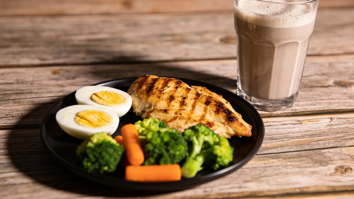 Perder músculo al adelgazar: el estudio que muestra cómo evitarlo con fuerza y proteína Plato con pollo, huevos y batido de proteína para no perder músculo al adelgazar