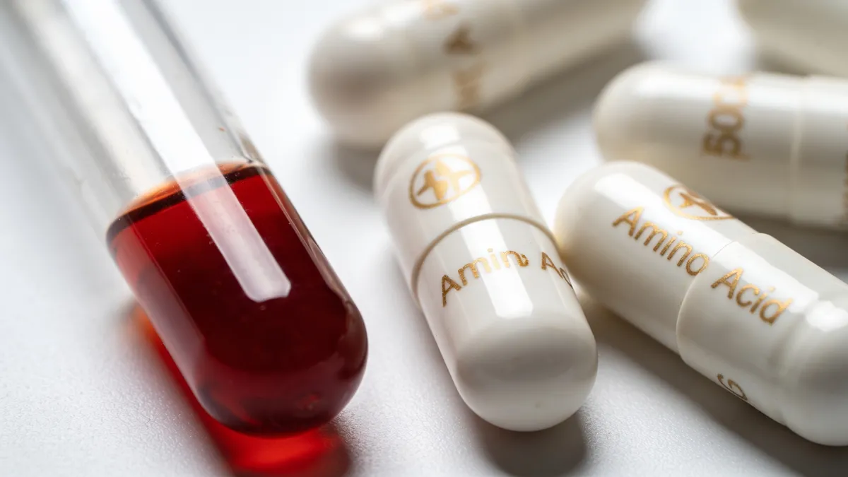 Tubo de analisis de sangre junto a capsulas de aminoacidos como la tirosina